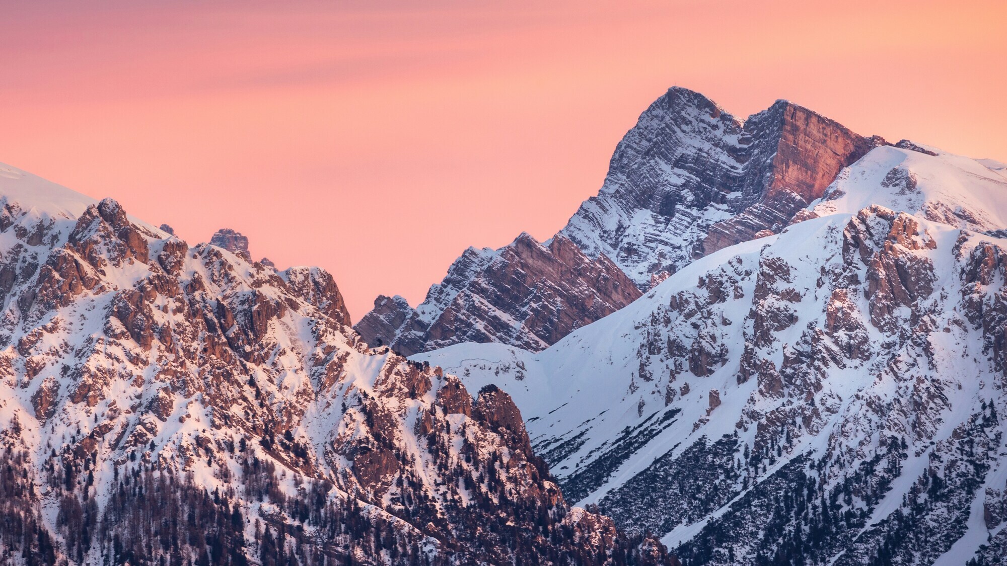 Snow-covered rocky peaks in pink evening light