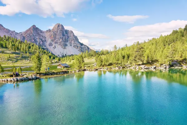 Lé Vert lake at Fanes pasture with green waters, hikers, hut & mountains