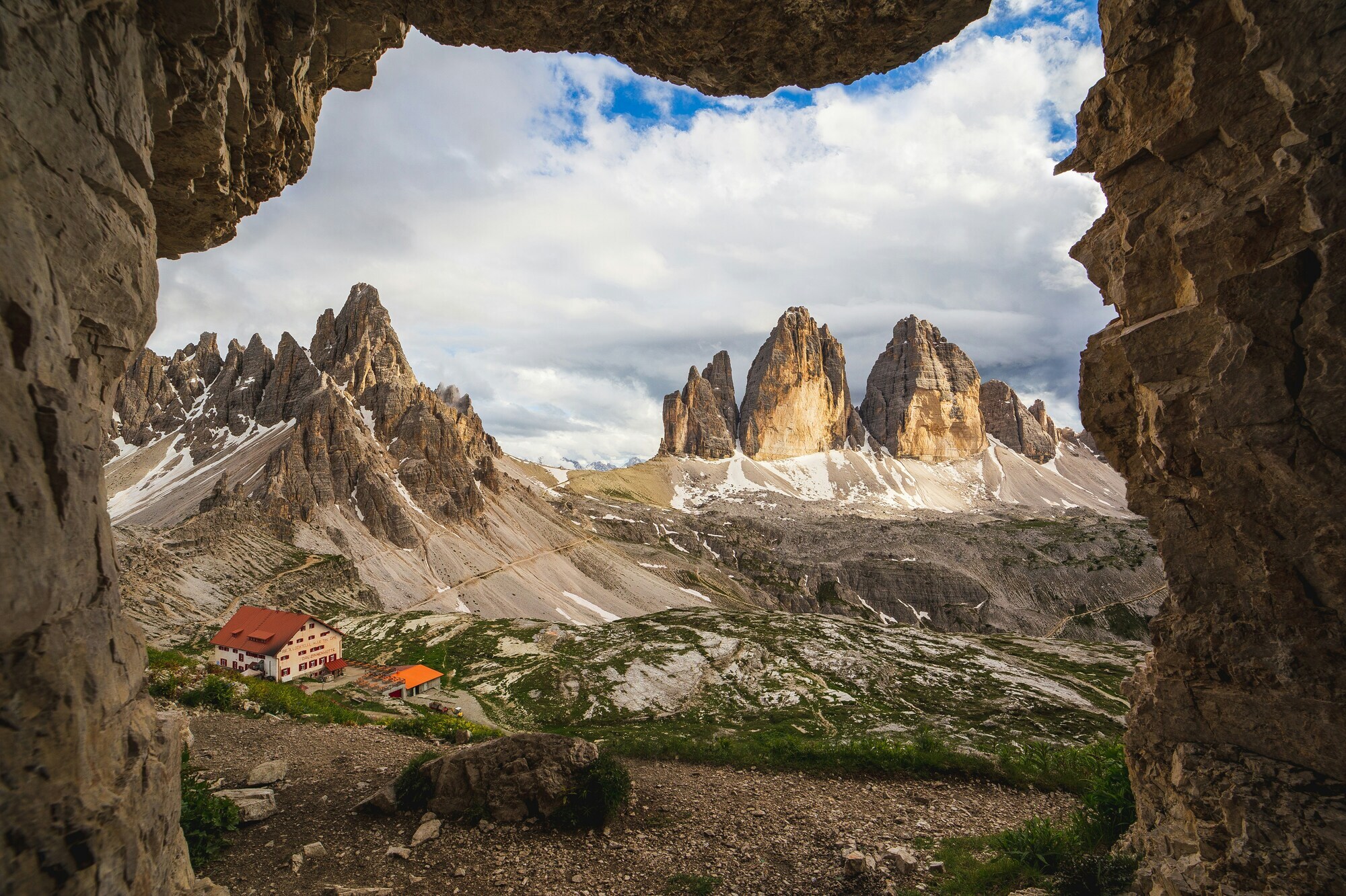 Dolomites peaks and huts seen from a hole in the rock