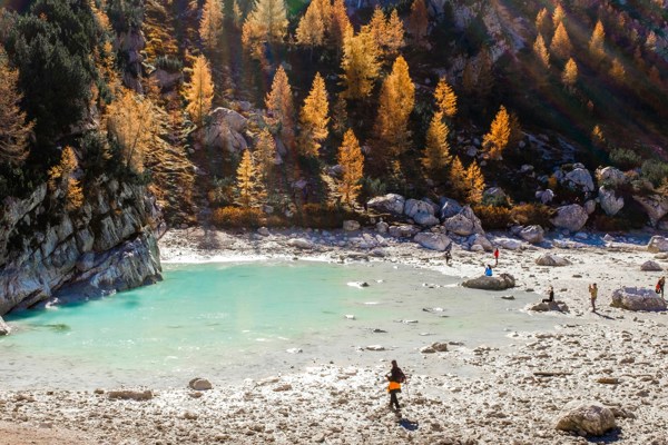 Lake Sorapis almost dried out with hikers and golden trees