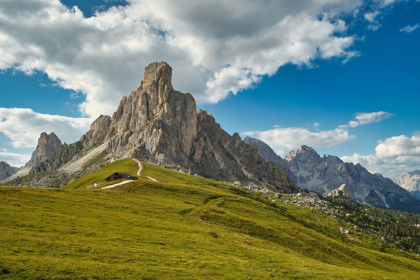 Mountain pass and peak in the background, with green meadows