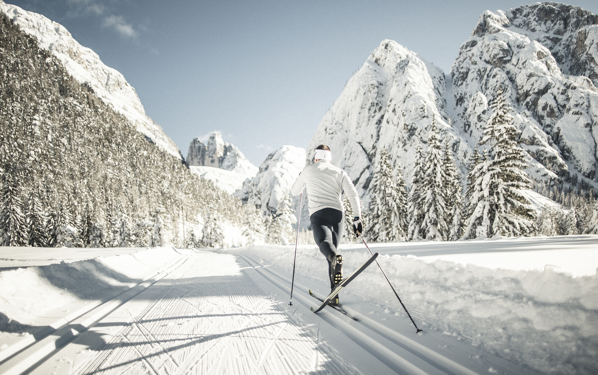 Cross-country skier on the trail in the midst of a snow-covered mountain world