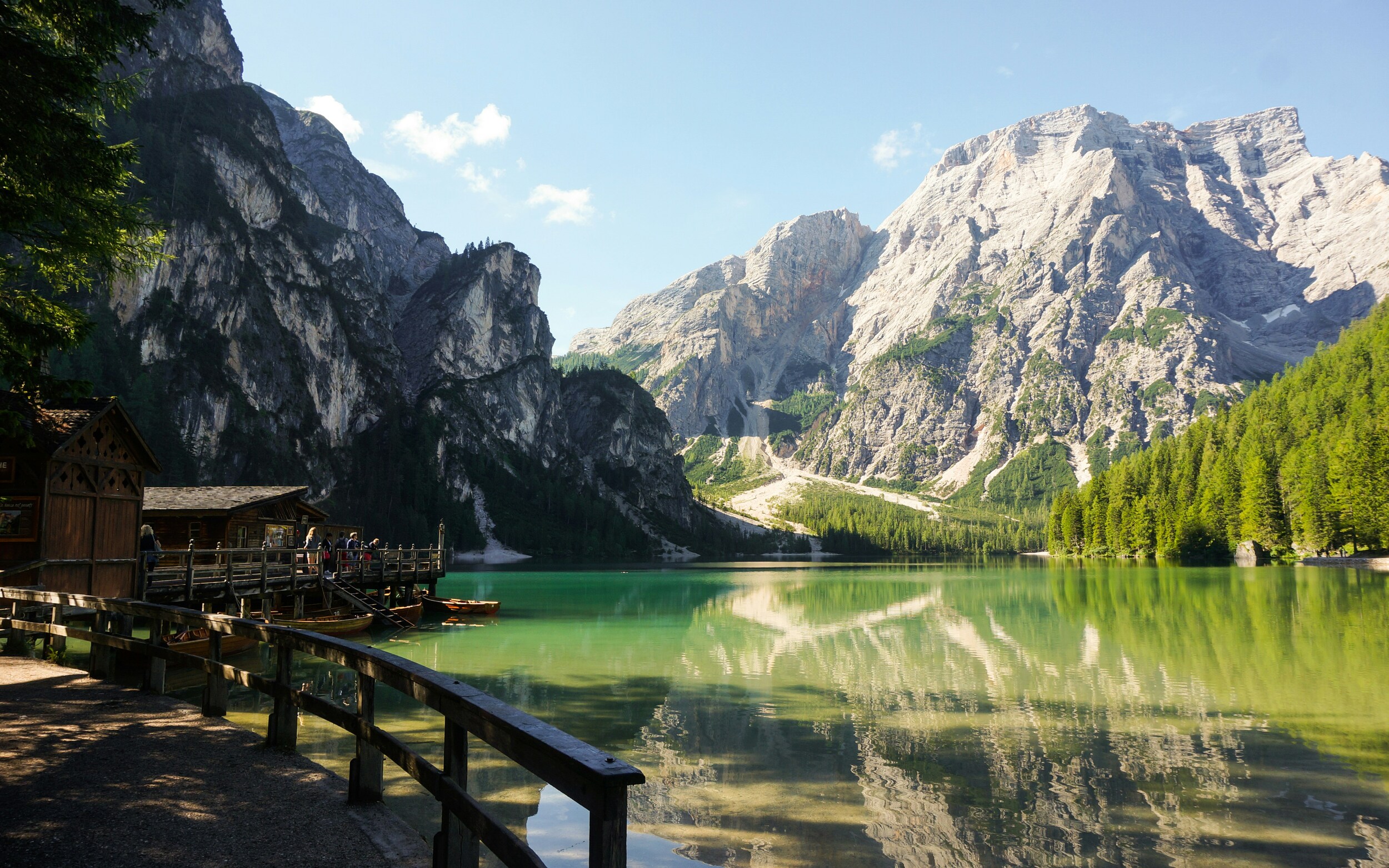 Path to a wooden hut on the shore of a turquoise mountain lake