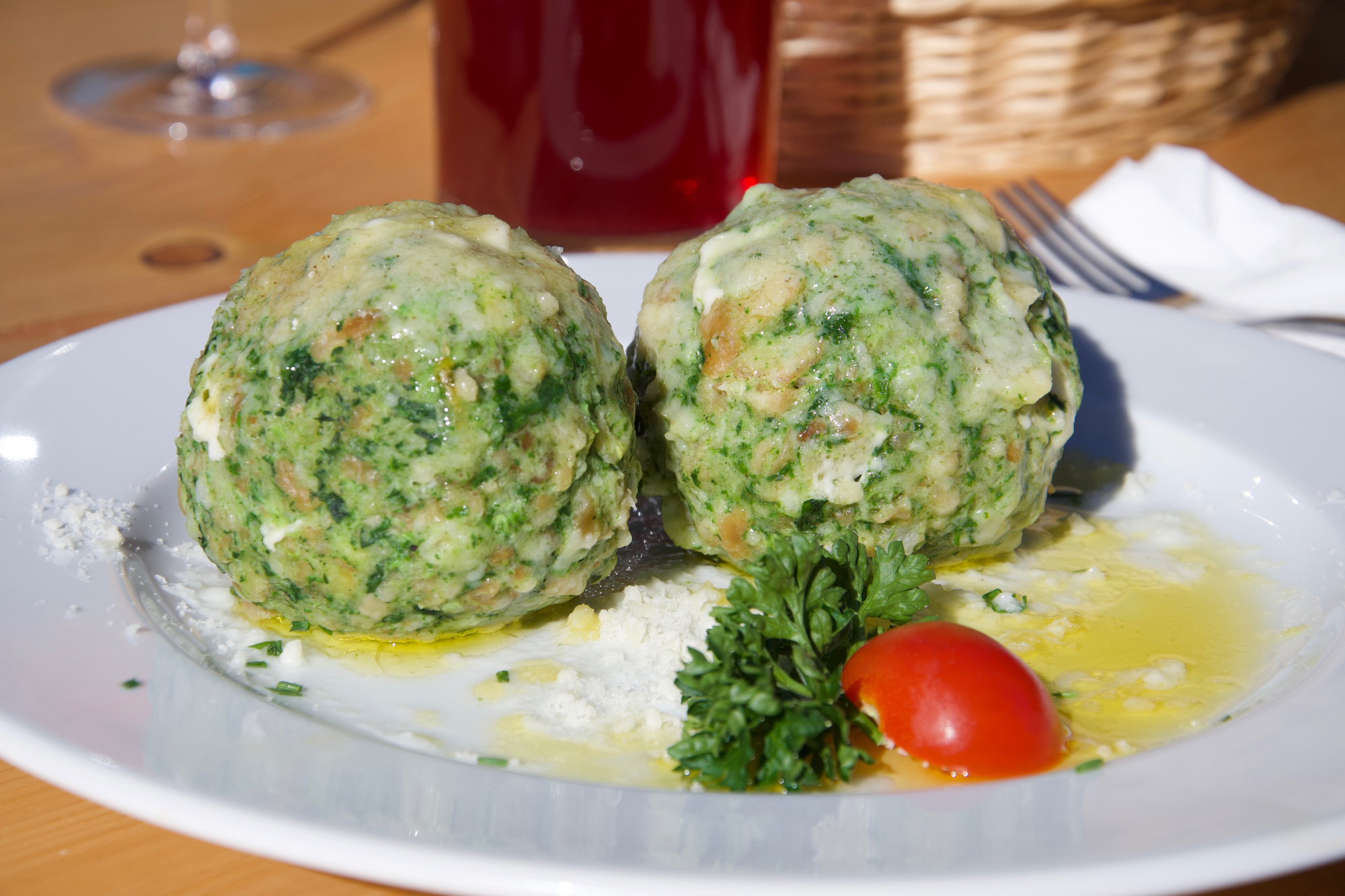 Spinach dumplings on a plate, with parmesan and tomato