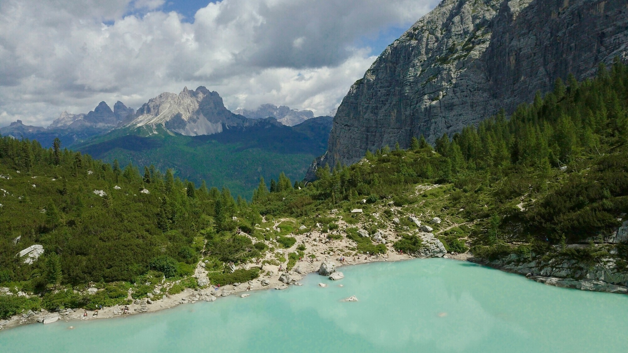 Mountain lake, with hiking trails, woods and peaks in the background