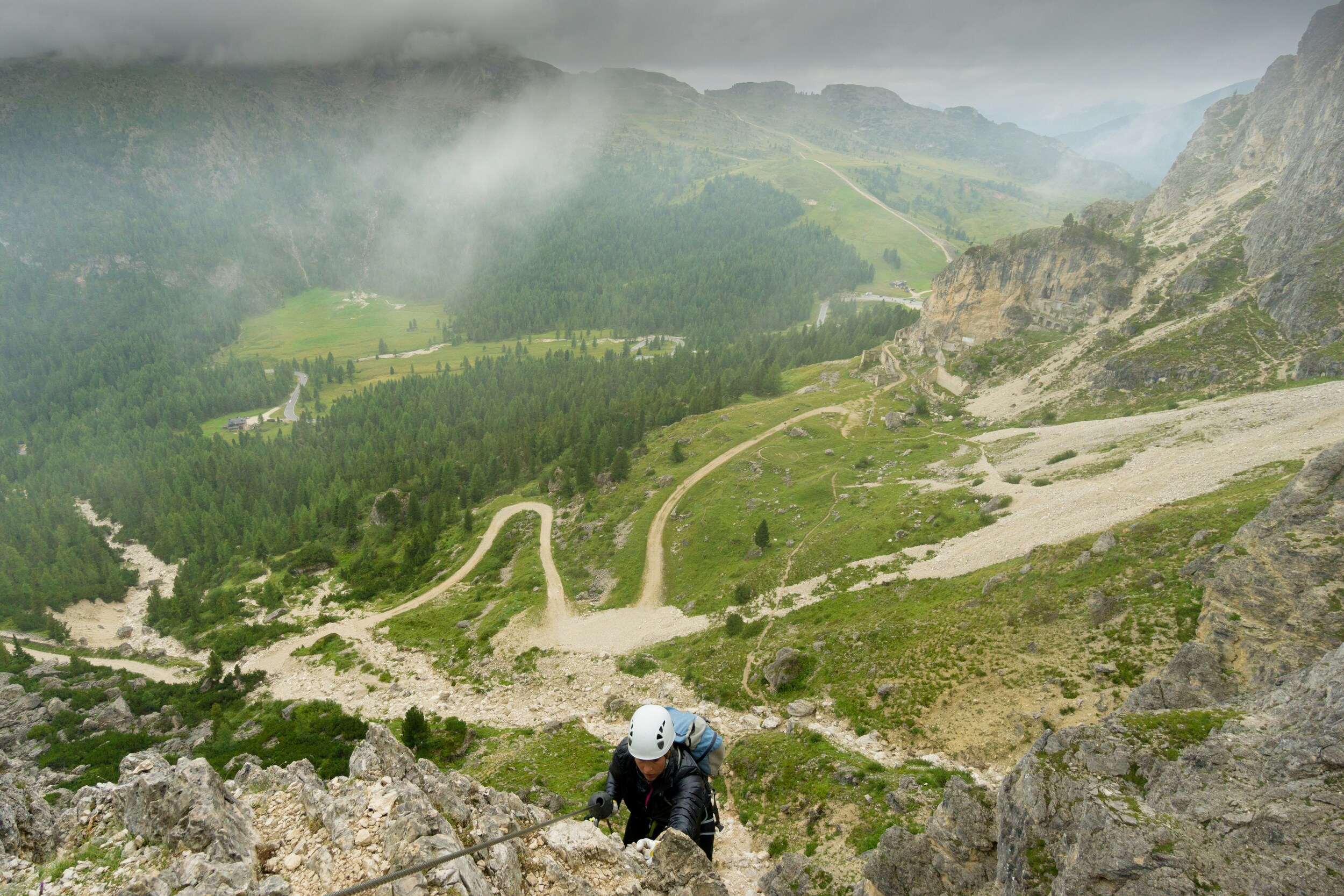 Climber on a via ferrata with pass road forest and natural scenery