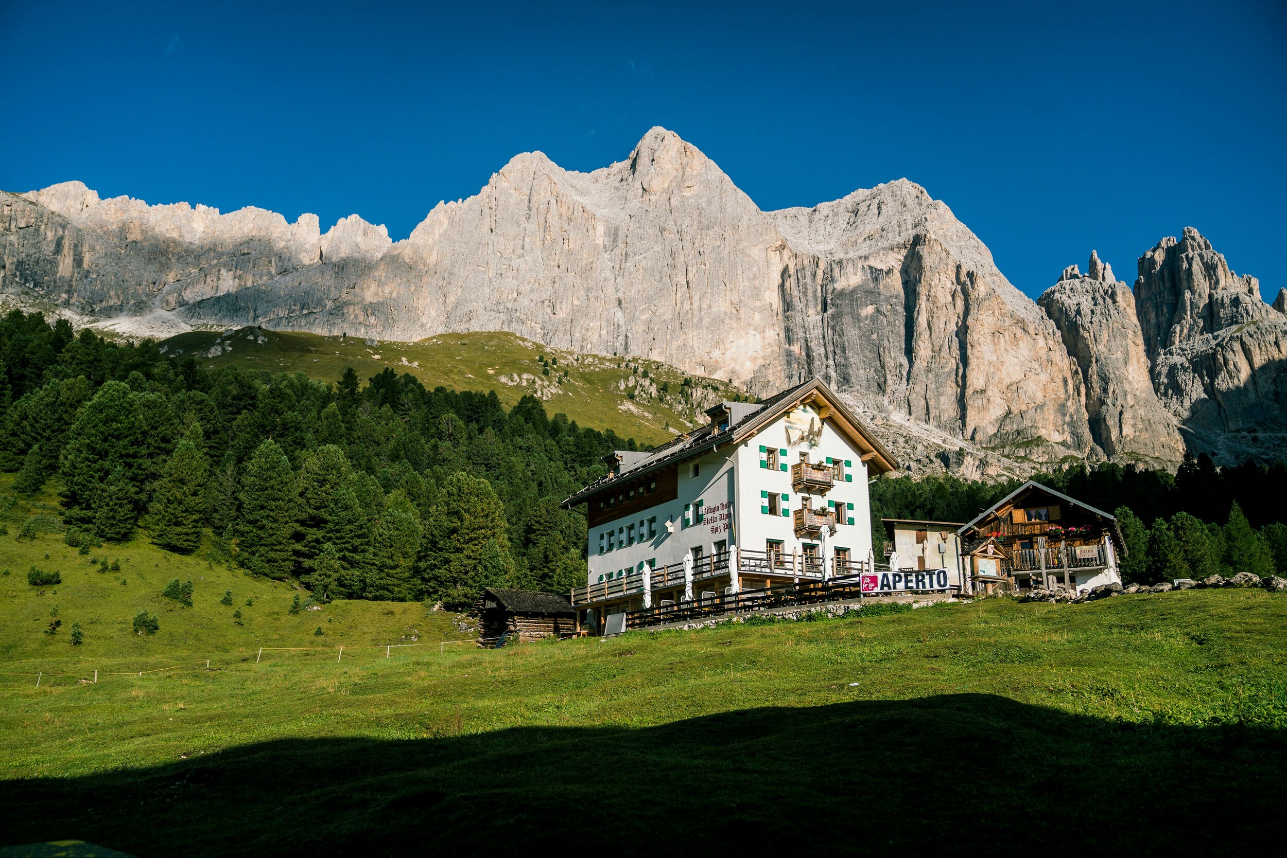 Mountain hut under a steep rock wall