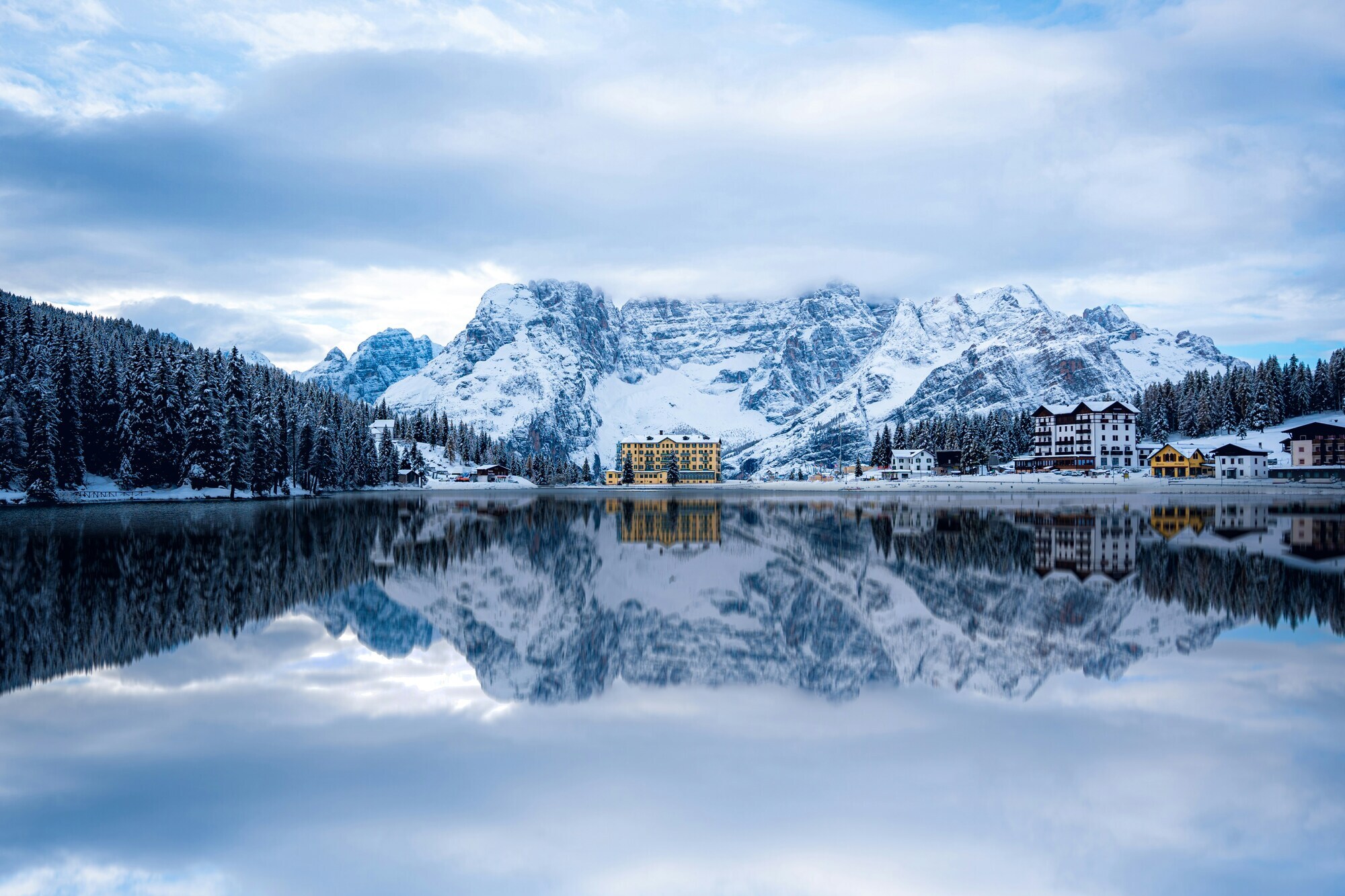 Houses and mountains reflected in a mountain lake in winter