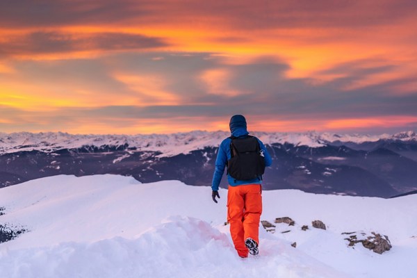 Hiker with backpack in the snow-covered mountains