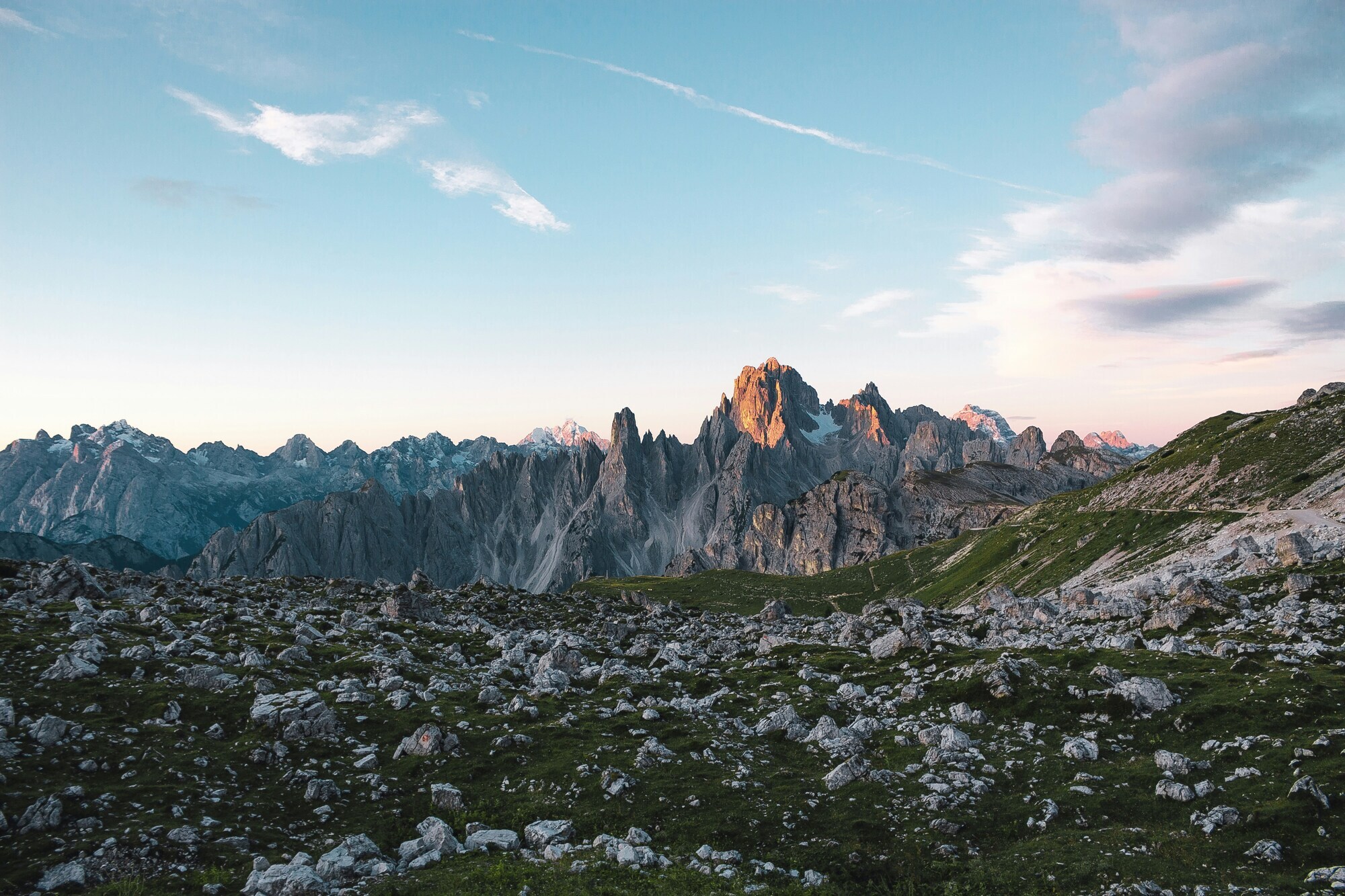 First morning light on the rugged Dolomites peaks with clear blue sky