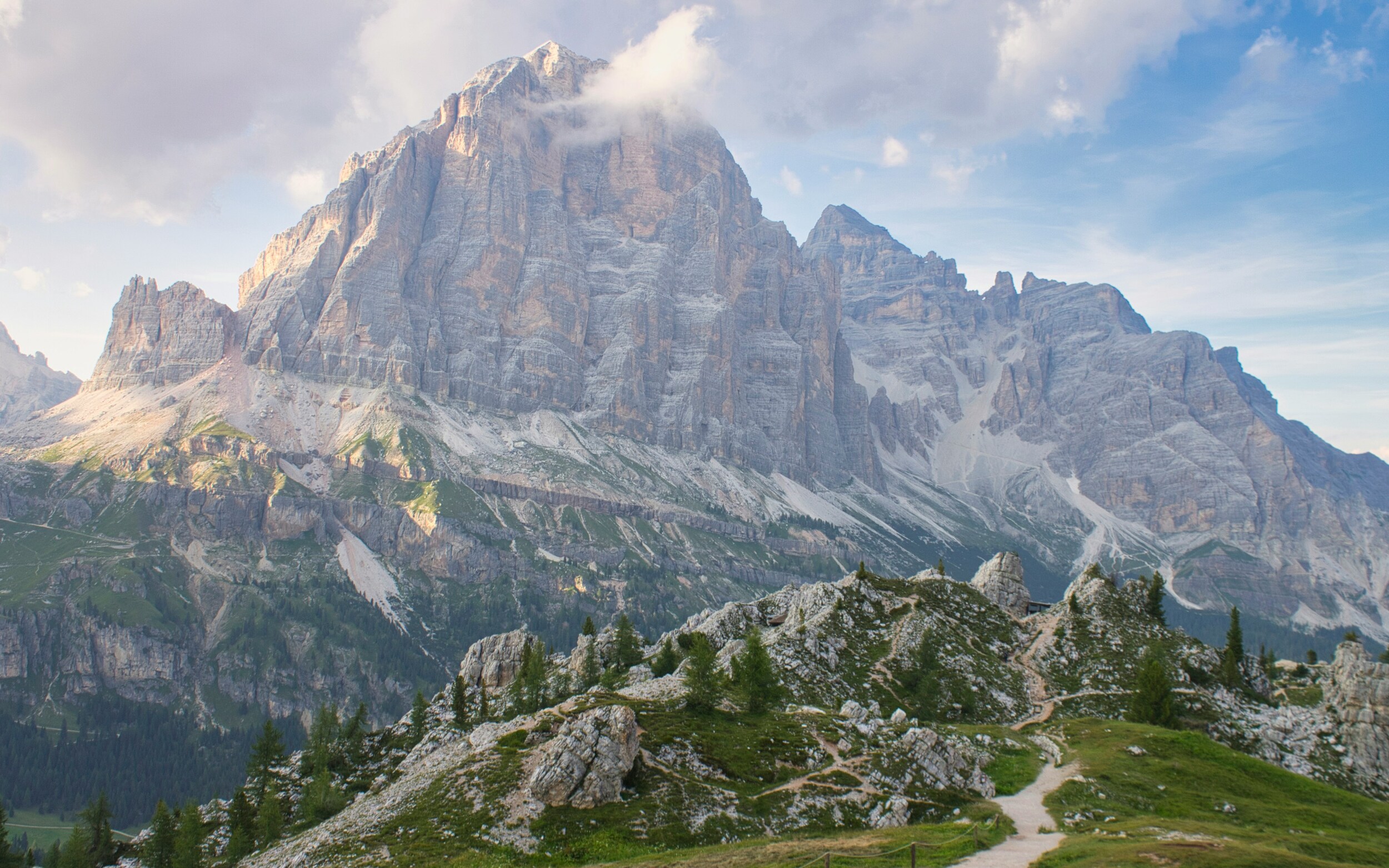 Dolomites rock wall with hiking trails in the foreground