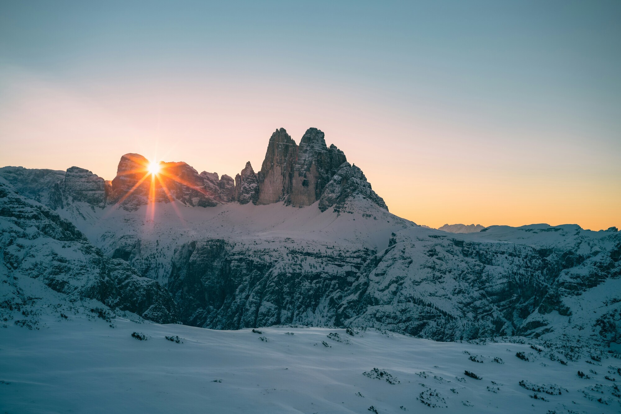 Sun rising over snow-covered mountains