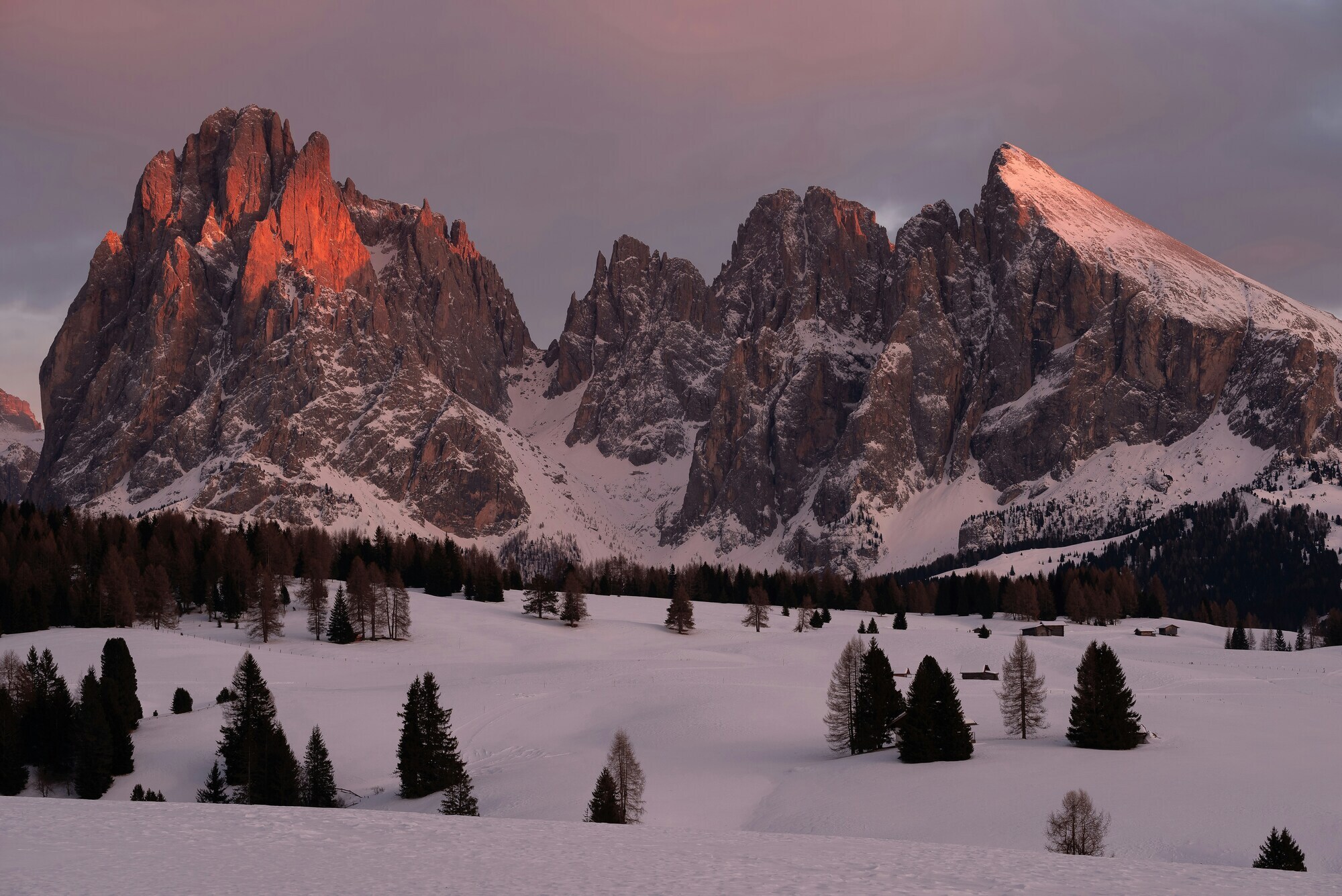 Winter mountain group behind a snow-covered landscape in the light of the sunset