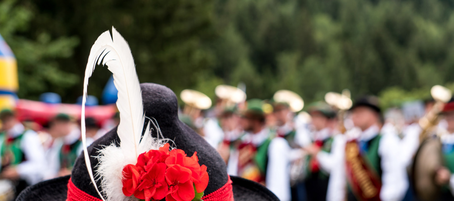 Black and red traditional hat with feather & marching band