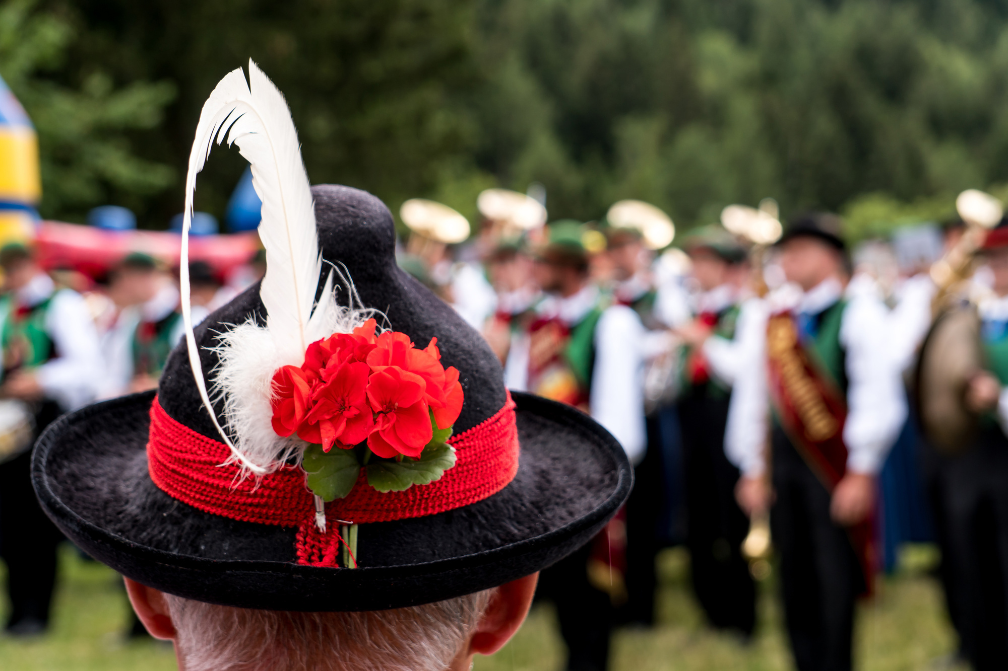 Black and red traditional hat with feather & marching band