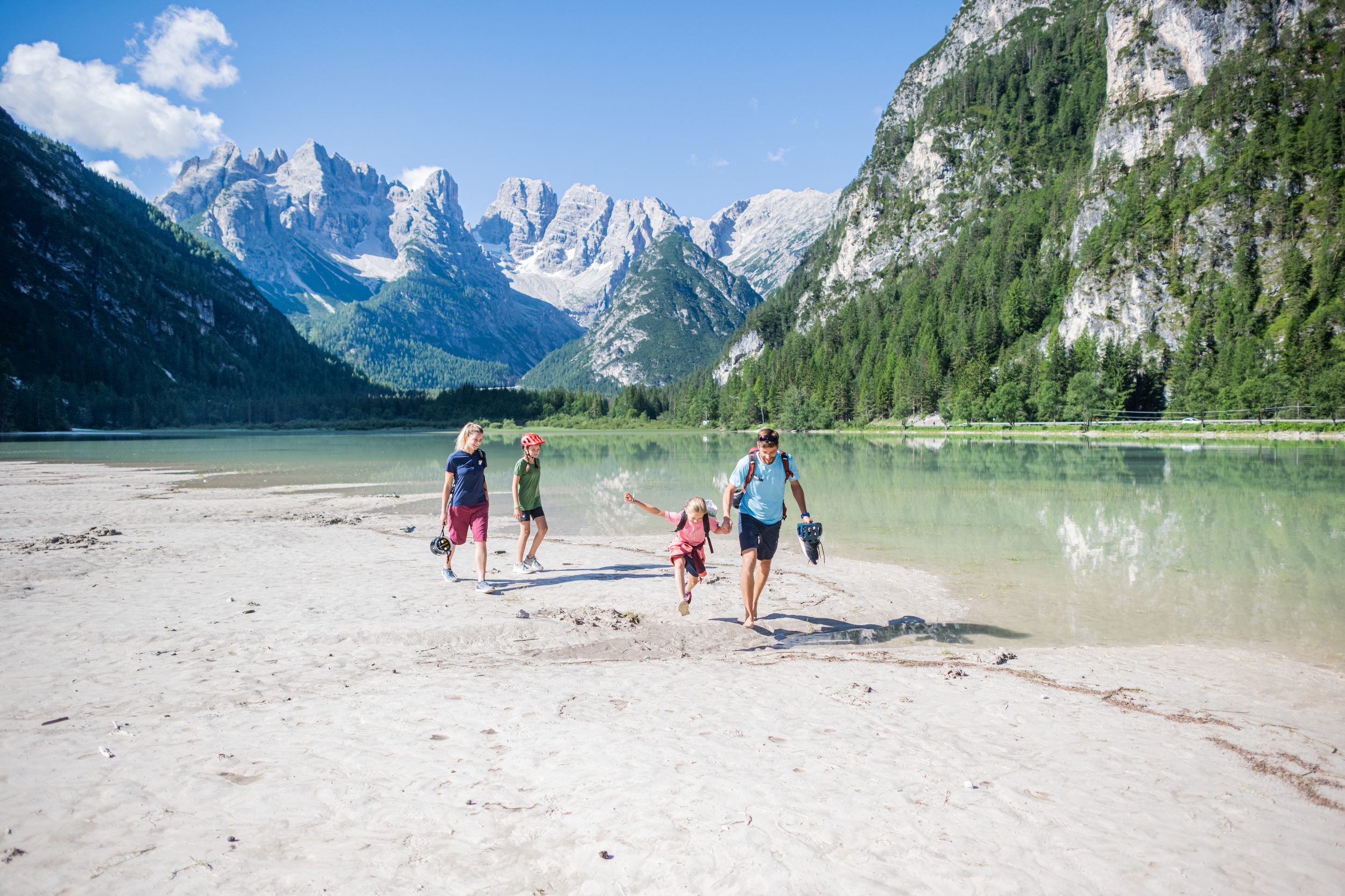 Family walking on the shore of a mountain lake