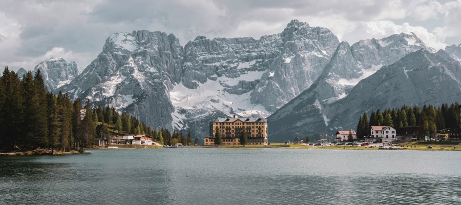 Houses and snow-covered mountains reflected in a mountain lake