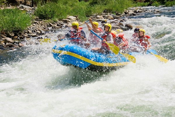 Several rafters at full speed on a rushing mountain stream