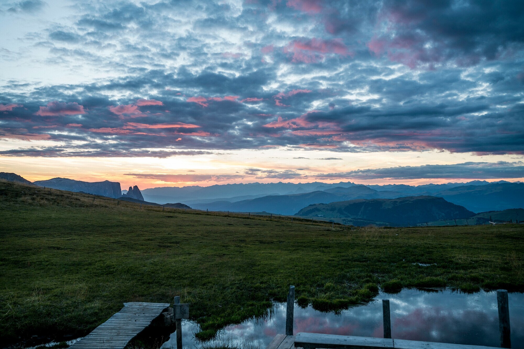 Sunset and pink clouds over a dark mountain landscape