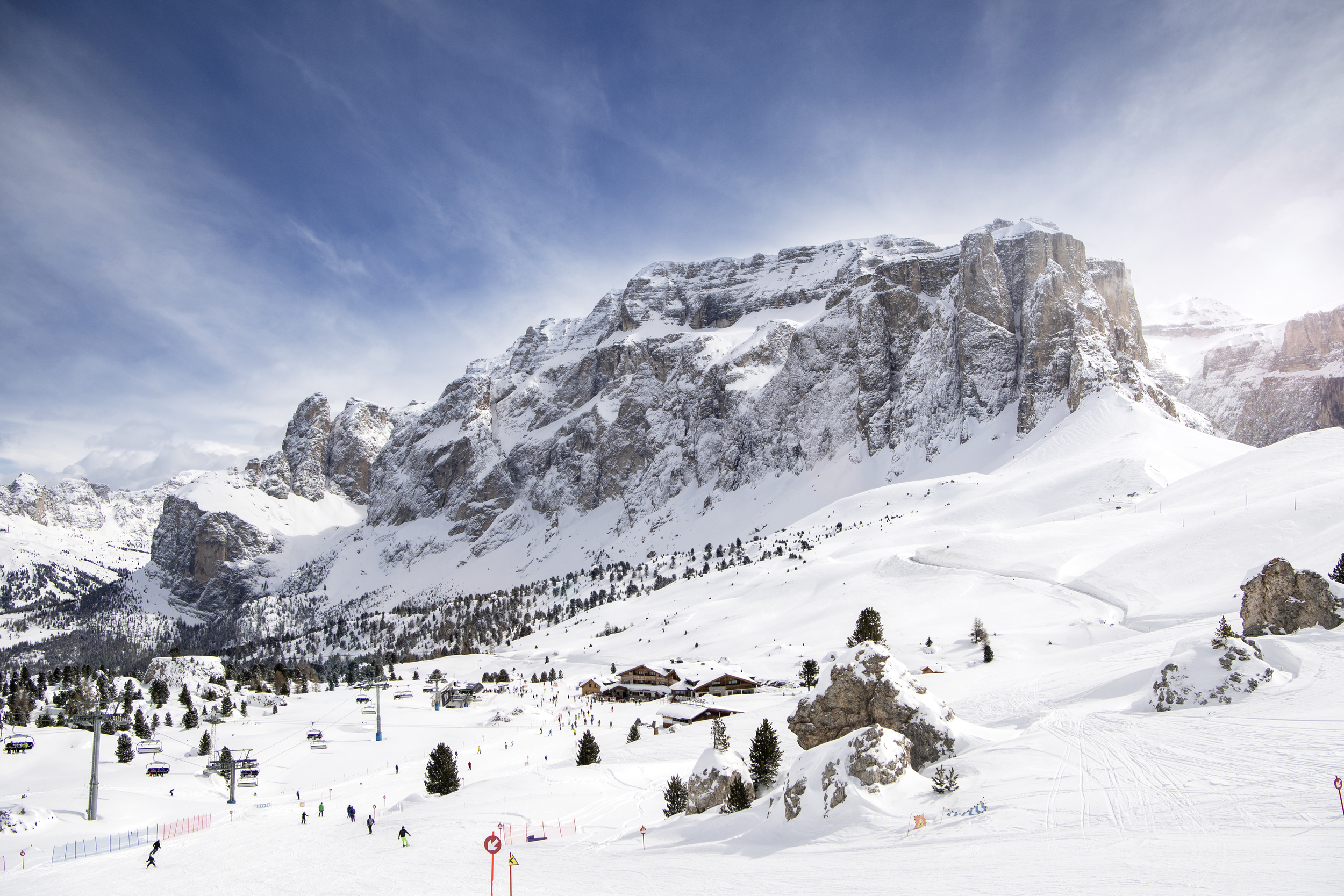 Ski run near rocks, huts and at the foot of mountains