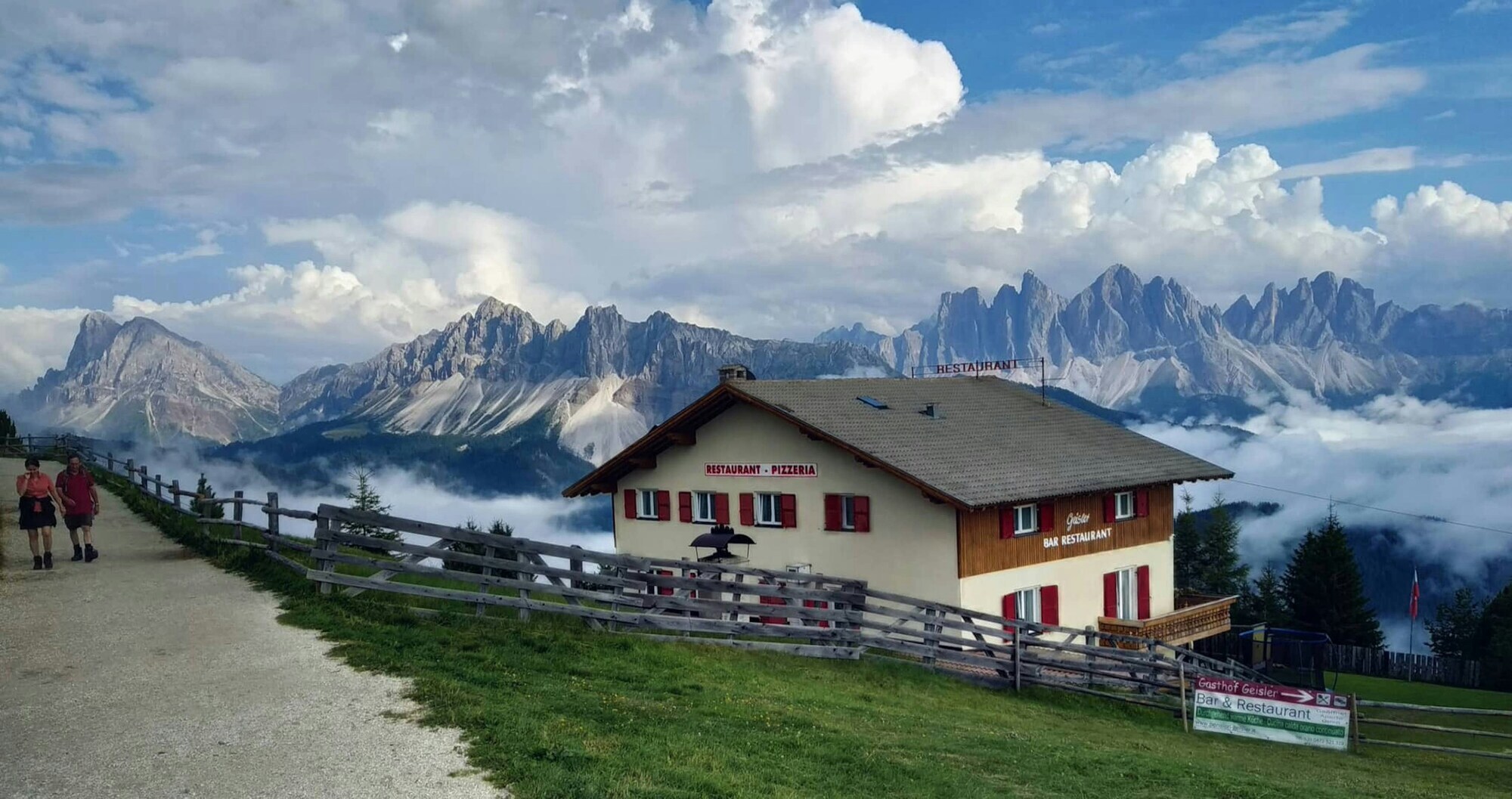 Mountain hut near hiking path with Dolomites view