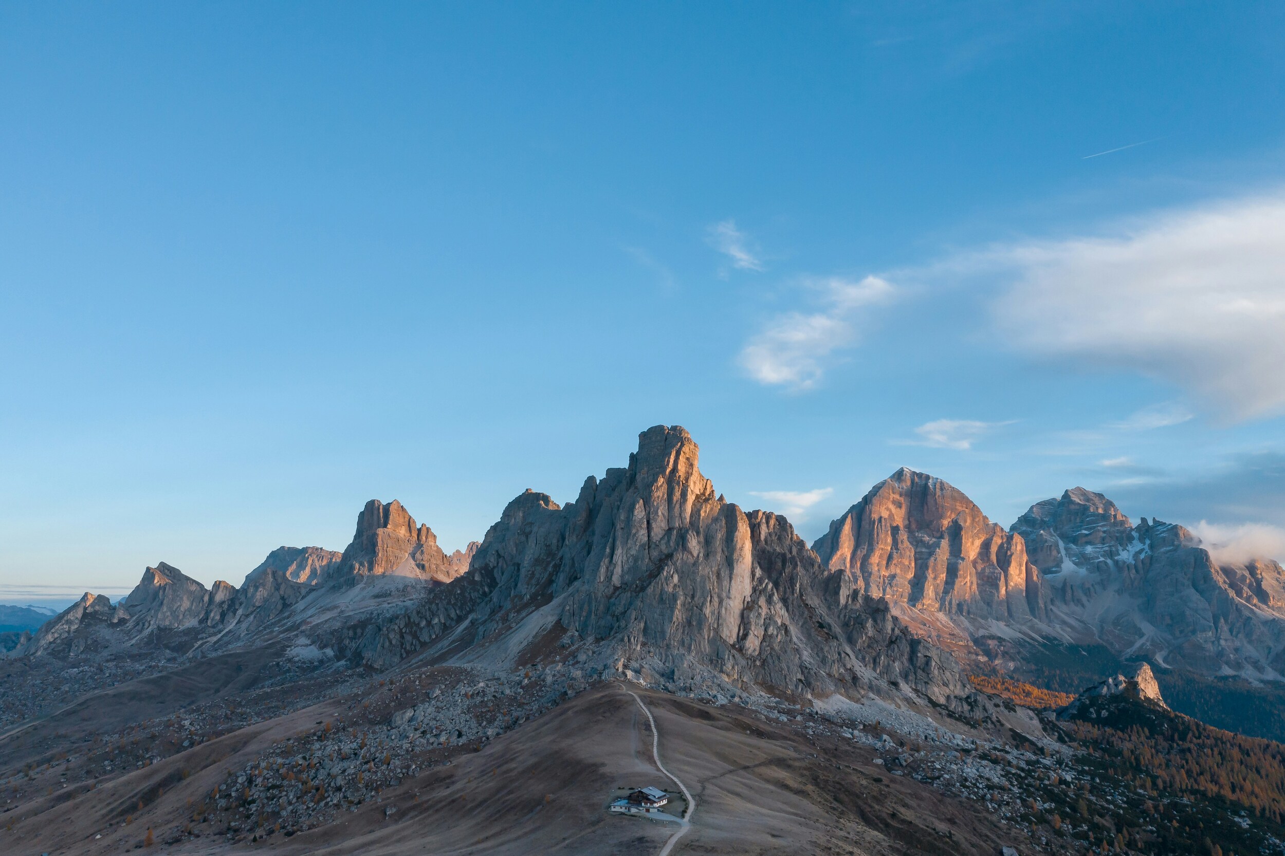 Hut, pass road and mountains at sunrise