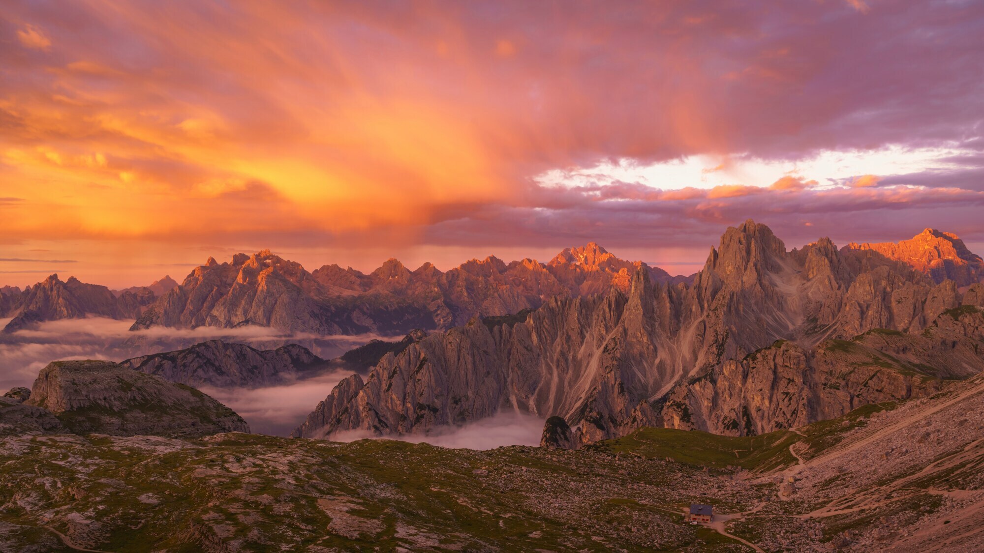 Sunrise in the mountains with red sky and view of a hiking trail