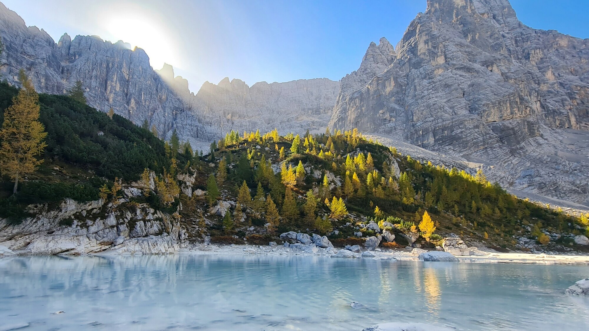 Blue mountain lake with peaks in the background at sunrise