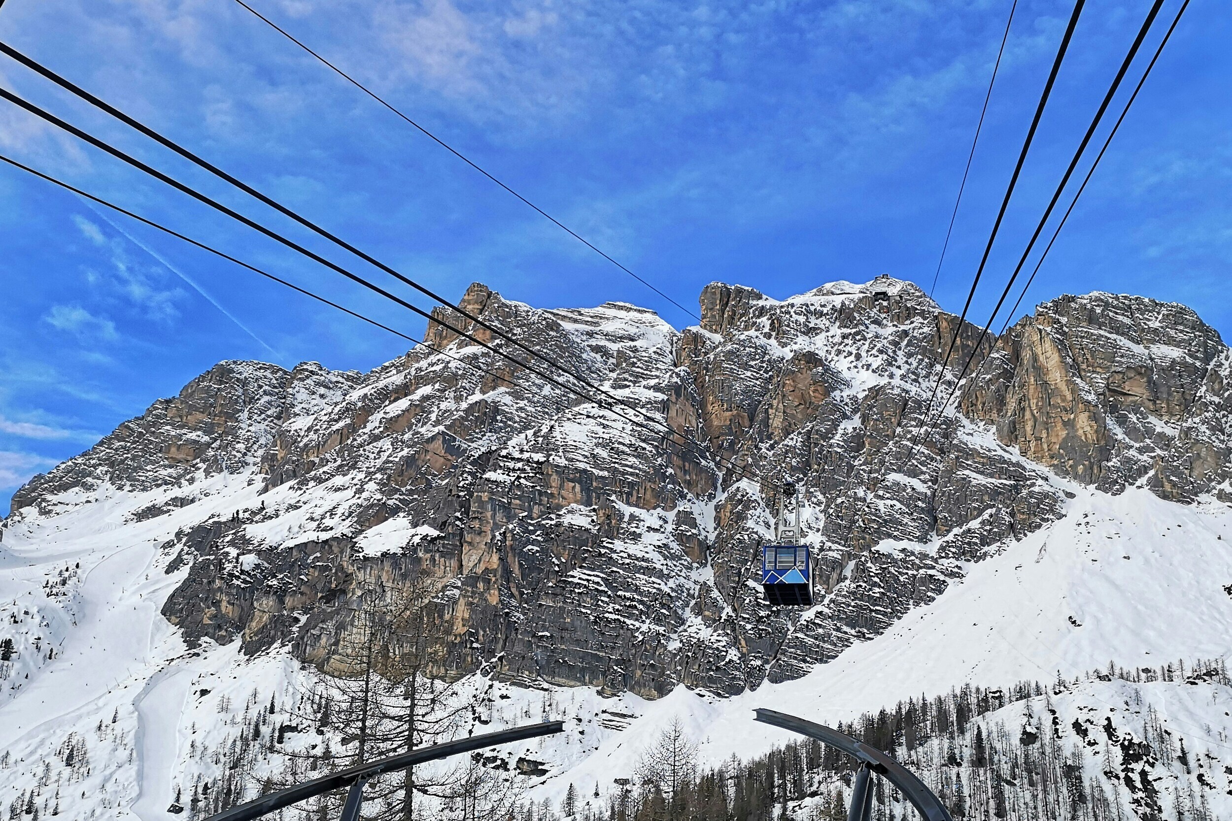 Cable car and snow-covered peaks and ski slopes