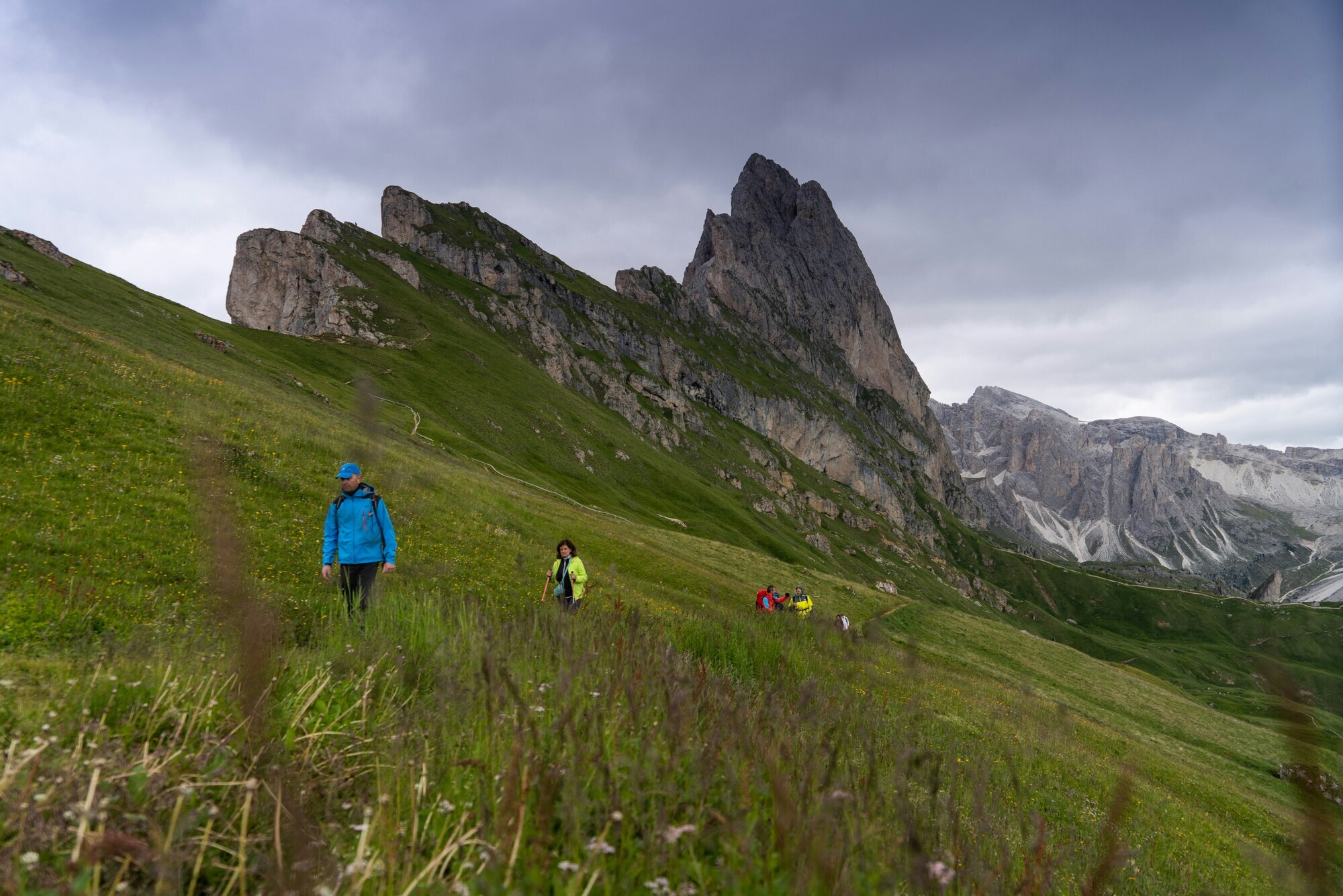 Hikers with colourful jackets in the mountains with cloudy sky