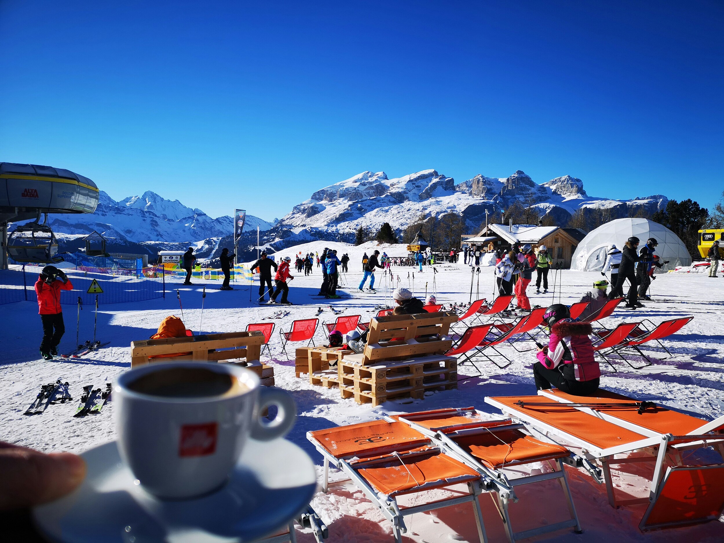 Person holding coffee with a view of the ski slope