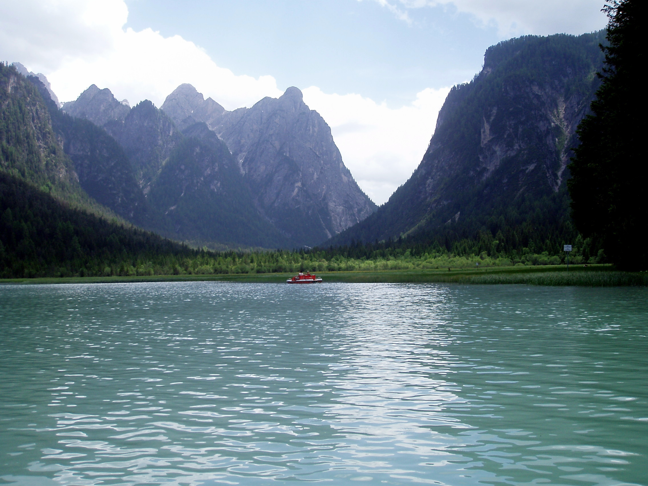 Small red pedalo on a lake in the middle of the mountains