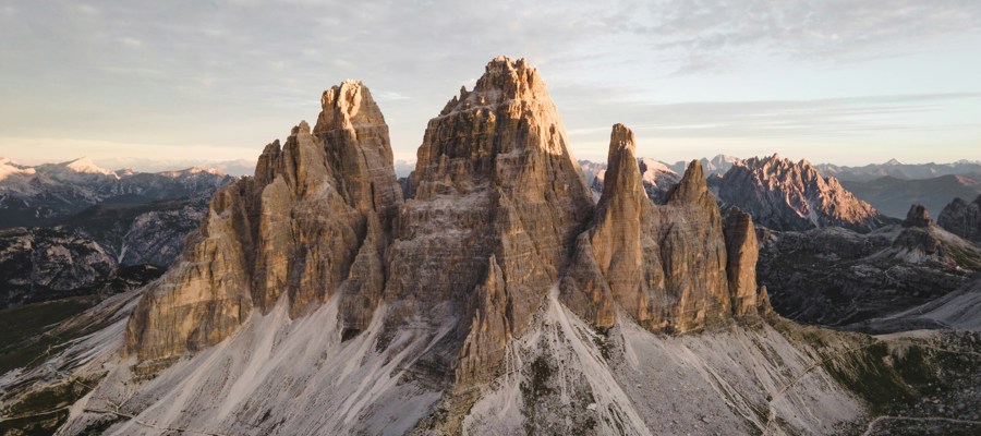 Rugged peaks with hiking trail below and cloudy sky