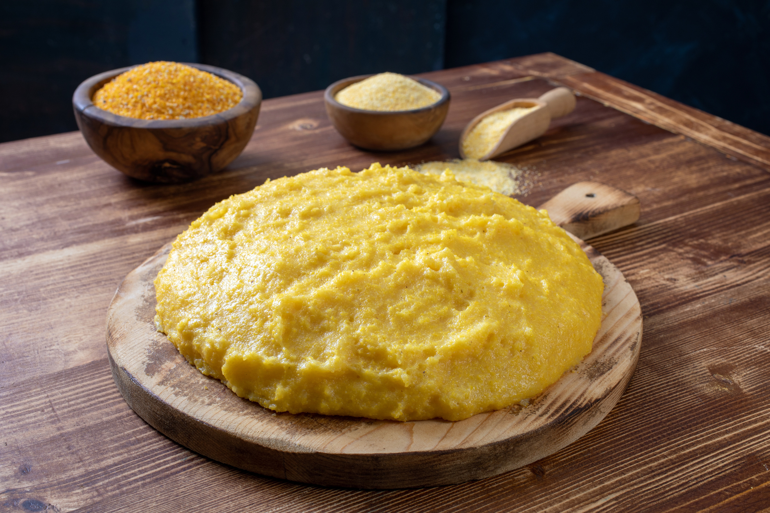 Cooked and raw polenta on a wooden table