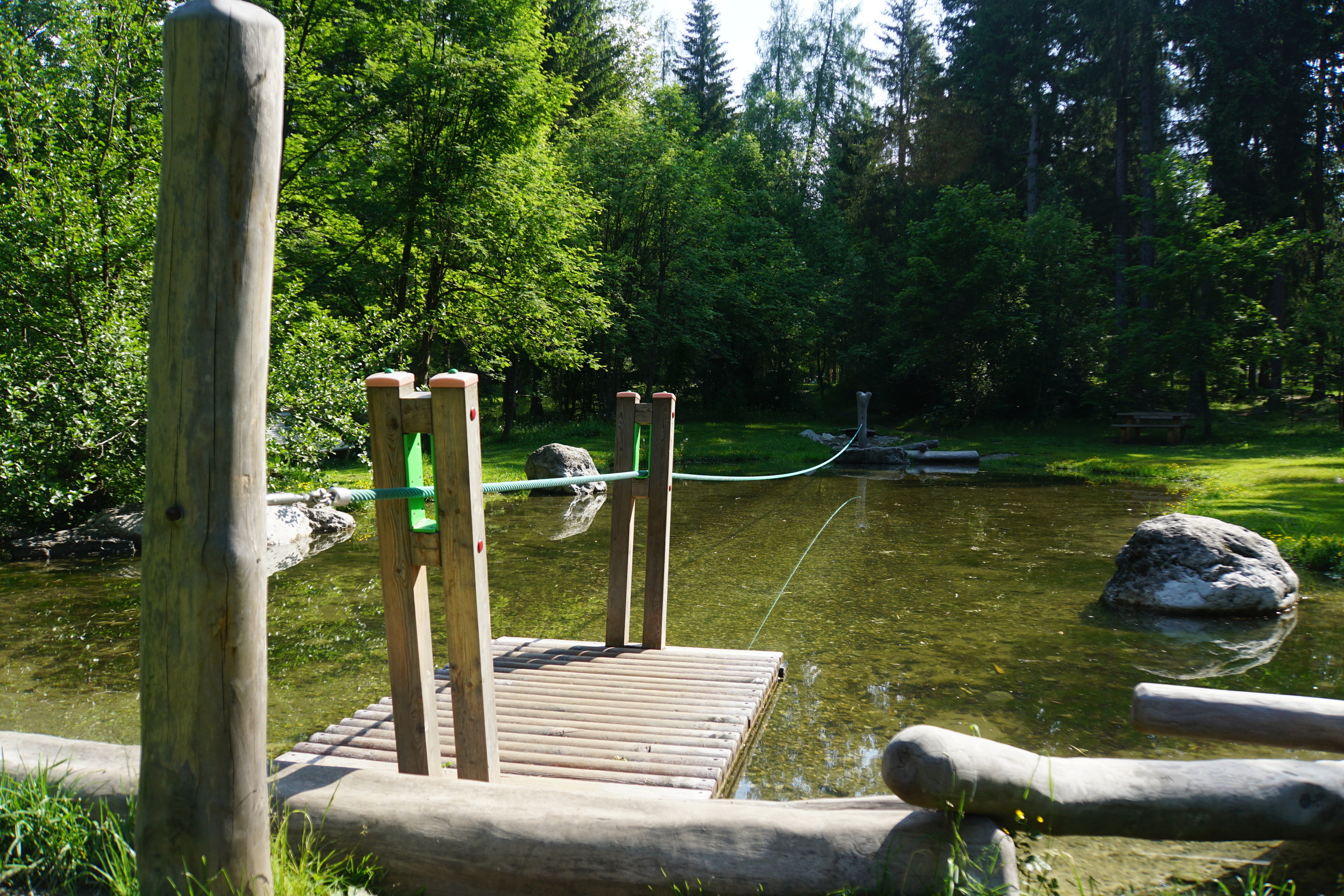 Raft with cable pull on a small pond in a green park