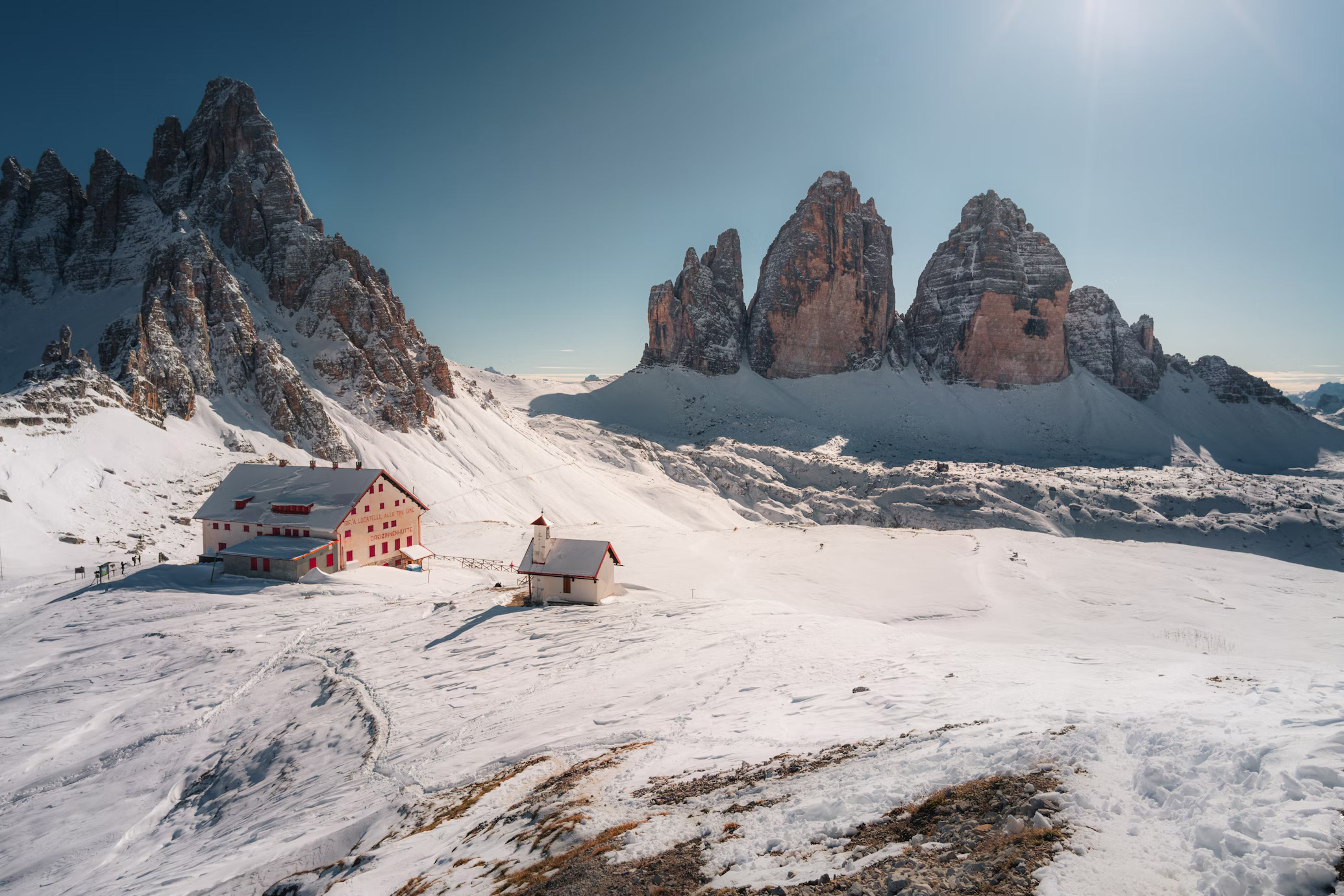 Tre Cime di Lavaredo with hut and snowcovered Dolomites peaks