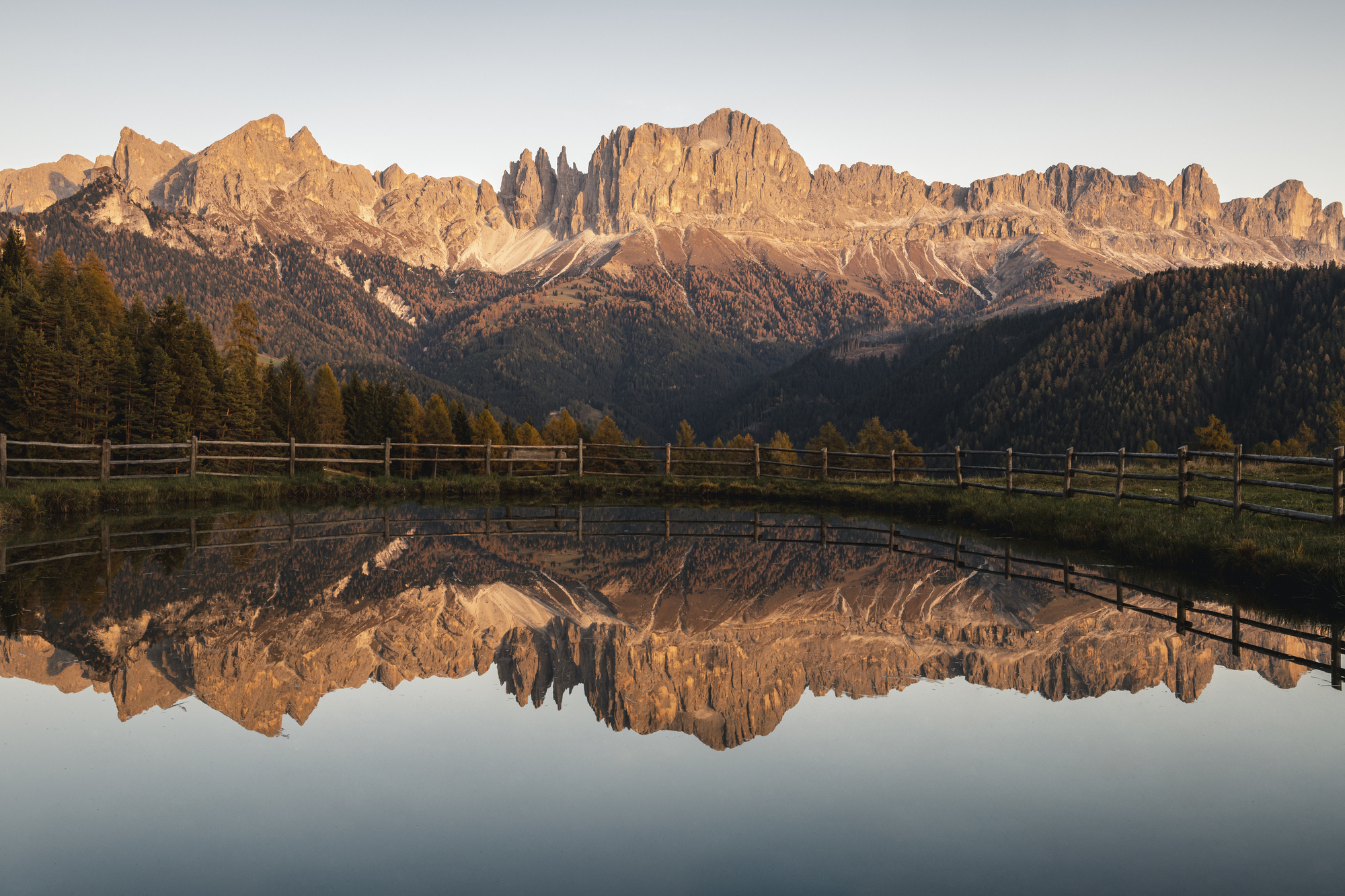 Enrosadira on a mountain range reflected in a lake