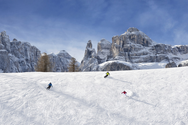 Skiers on the slopes with a mountain panorama in the background