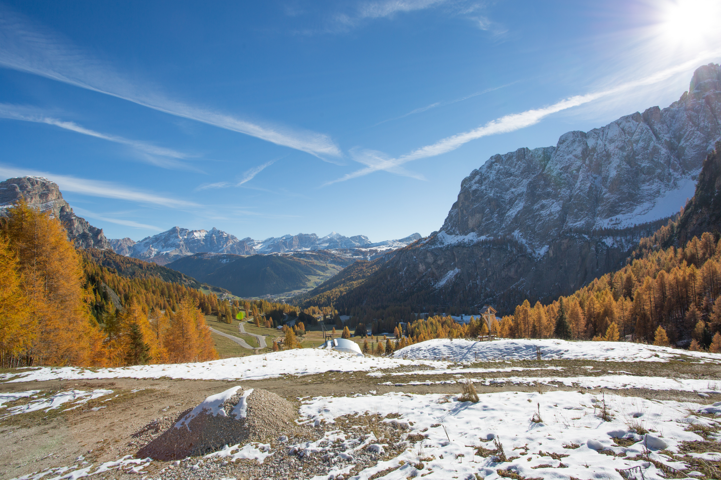 Autumnal mountain landscape with yellow larches and a little snow